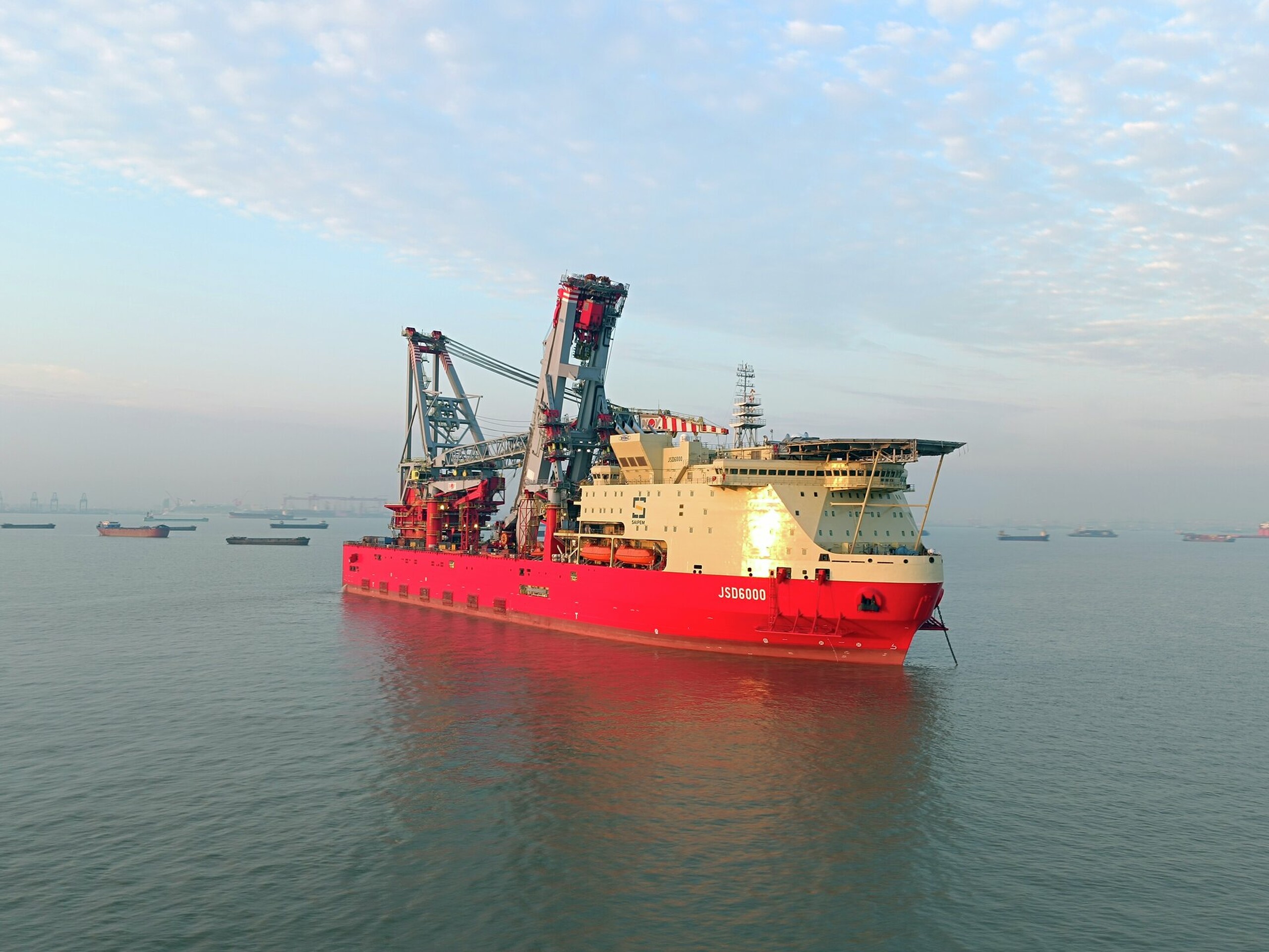 The heavy lift pipelay vessel, ‘JSD 6000’, is a customised ULSTEIN SOC5000 design. The 215m long DP3 vessel is equipped with a 5,000t revolving main crane and will be cable of performing J-lay and S-lay pipelay work in max water depths of 3,000m.. The combination of heavy lift and S-Lay capabilities together with J-Lay functionality via a large, off-centre moonpool, allows the vessel to serve deepwater and SURF markets as well as shallow-water EPCI projects.  The JSD 6000 vessel is the third cus