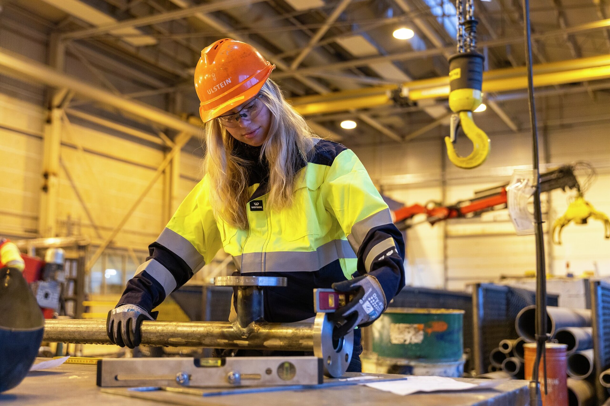 Industriarbeider som måler et rør